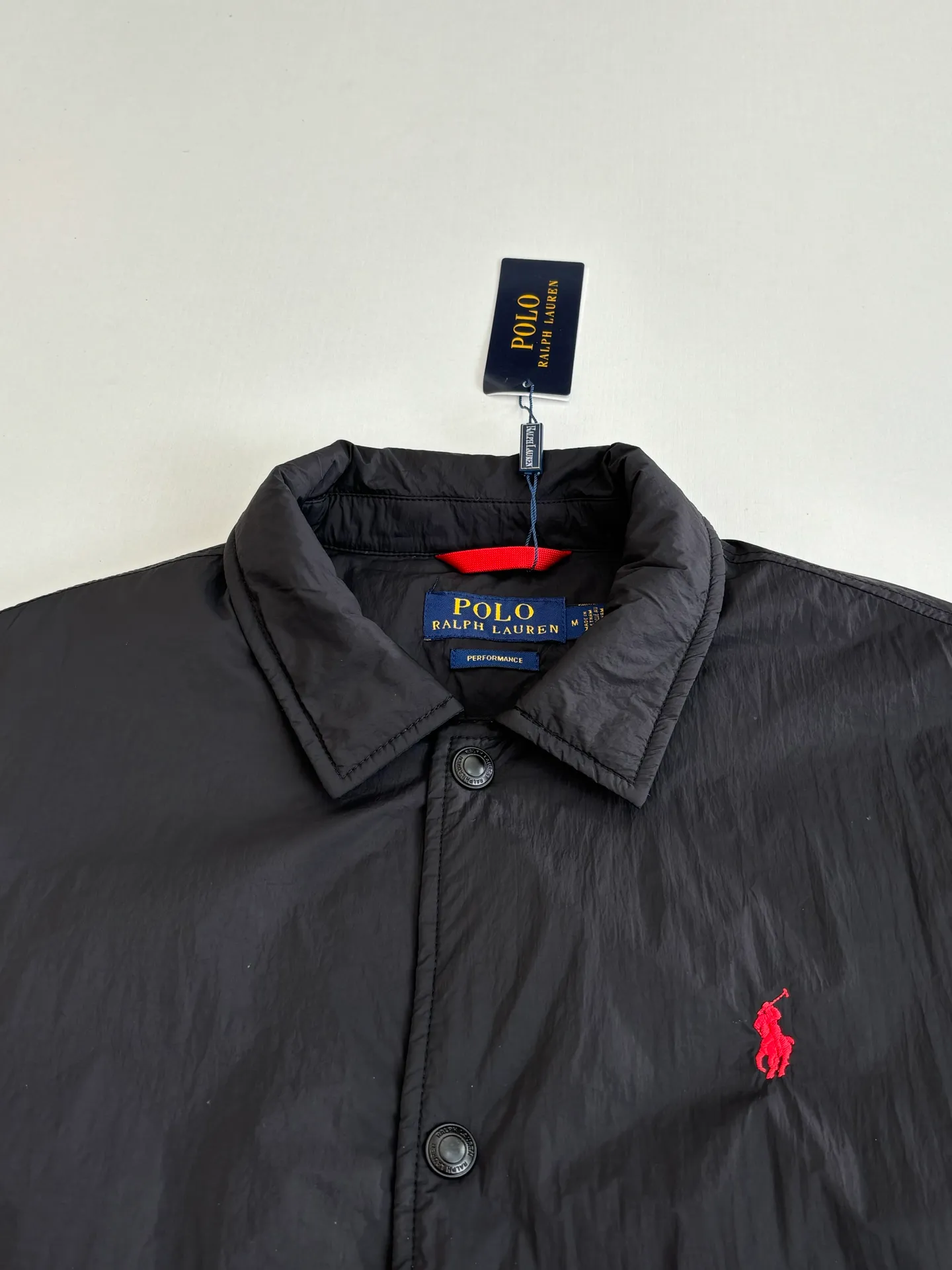 P670 Ralph Laure*/Ralph Lauren 25FW red label thin cotton coach jacket. The surface material is made of high-density nylon taffeta with a density of about 210T-300T. The surface is smooth and slightly matte. It has excellent windproof and waterproof performance (with DWR water-repellent treatment). It has strong wrinkle resistance and is easy to care for. It is in line with the positioning of American casual "durable and practical". Lining: Lightweight cotton-polyester blend lining (65% Polyester + 35% Cotton) Embroidery positioning: Precisely position through the template (12cm from the bottom of the neckline, 8cm from the placket) to ensure left and right symmetry and centering.  Size：S/M/L/XL